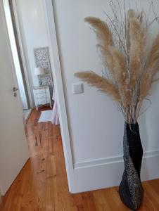 a black vase with feathers in the corner of a room at Appartement Pont Luiz in Porto