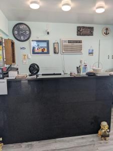 a counter in a restaurant with a clock on the wall at Tide Winds Motel in Wildwood