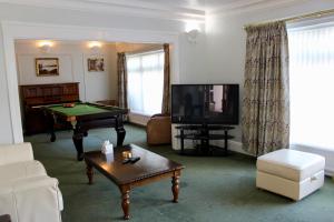 a living room with a pool table and a tv at Bryn Noddfa in Morfa Nefyn