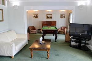 a living room with a pool table and a tv at Bryn Noddfa in Morfa Nefyn