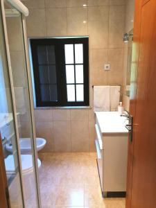 ValdosendeにあるRestaurante Vessada - Alojamento Localのバスルーム(洗面台、トイレ付)、窓が備わります。