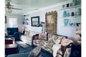 un salon avec un canapé et une chaise dans l'établissement 1 mile to Fort Sill! The CaroleBelle Cottage sleeps 8 with hottub,grills,firepit, à Lawton