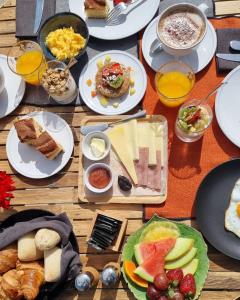a wooden table with plates of food and drinks at SENSI Azores Nature and SPA in Ginetes