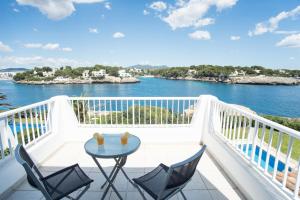 balcón con mesa y sillas y vistas al agua en Villa Forti 57, en Cala d´Or