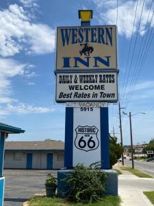 um sinal para uma pousada ocidental numa rua em Western inn em Tulsa