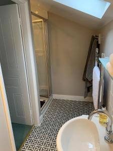 a small bathroom with a sink and a shower at Centre Chipping Campden - 3 Bedroom Cottage for 5 in Chipping Campden