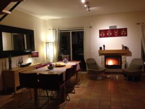 a living room with a table and a fireplace at Casa Estelliane in Paderne