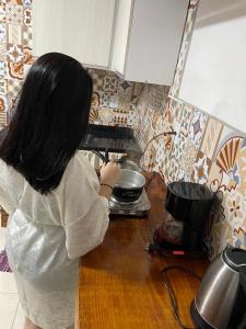 a woman is preparing food in a kitchen at Studio Imbé in Imbituba +16 photos