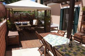 a patio with tables and chairs and a white umbrella at Casa Estelliane in Paderne