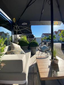 a patio with a couch and an umbrella at Hotel Azur in De Haan