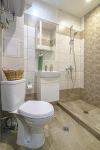 a bathroom with a toilet and a sink and a shower at Chayka Comfort Apartment in Varna City