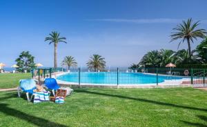 a child sitting in a chair next to a swimming pool at La Roca Sea View Apartment in Torremolinos +10 photos