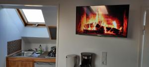 a kitchen with a fire hanging on the wall at Tinyloft in Beerfelden