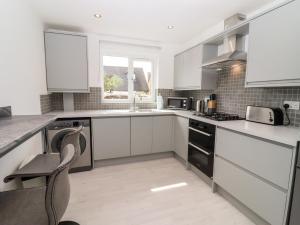 a kitchen with white cabinets and a stove top oven at 3 Granbrook Lane in Chipping Campden +14 photos