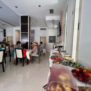 un grupo de personas sentadas en una mesa en una cocina en Hotel Ergi, en Durrës