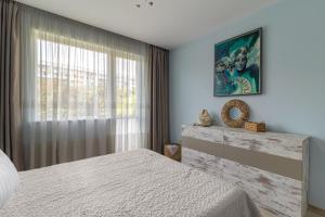 a bedroom with a white bed and a window at Chayka Comfort Apartment in Varna City
