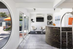 a room with a counter with two white chairs at The Palm Springs Hotel in Palm Springs