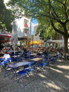 a group of tables and chairs with people sitting around them at Luxury Gemütliche WOHNUNG in Eigelstein Köln in Cologne