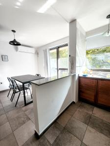 cocina y comedor con mesa y barra en CÓMODO Y LUMINOSO DEPARTAMENTO TEMPORARIO en Córdoba