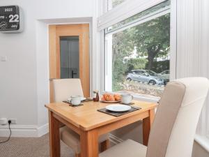 une table à manger avec des chaises blanches et une fenêtre dans l'établissement Flat 1 Byfield, à Torquay