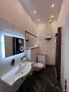 a white bathroom with a sink and a toilet at Urban Serviced Apartments in Vienna