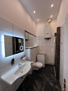 een witte badkamer met een wastafel en een toilet bij Urban Serviced Apartments in Wenen