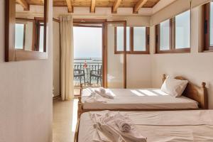 two beds in a room with a balcony at Saint Loukas Studios in Zakynthos