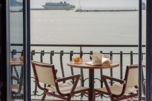 a table with chairs and a book on a balcony at Saint Loukas Studios in Zakynthos