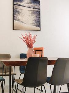 a dining room table with chairs and a vase on it at Villa Olive Hill in Dobra Voda +11 photos