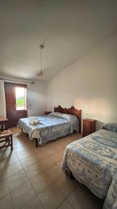 sypialnia z 2 łóżkami i oknem w obiekcie Agriturismo da Lino AGRIPIZZA w mieście Samughèo