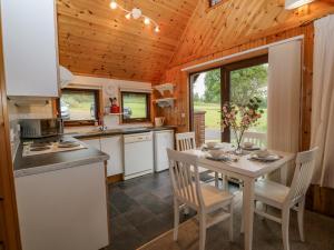 uma cozinha e sala de jantar com mesa e cadeiras em Lodge 16 em Camelford
