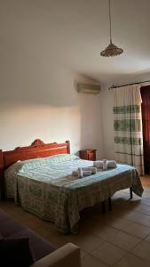 una camera da letto con un grande letto con asciugamani di Agriturismo da Lino AGRIPIZZA a Samughèo