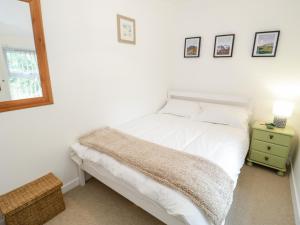 una camera da letto con un letto con lenzuola bianche e un comodino di 4 Gerlan Road a Bangor