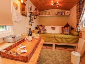 een woonkamer met een bank en een tafel bij Bracken Hut at Copy House Hideaway in Barnoldswick