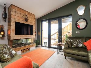 a living room with a fireplace and a tv at The Barn at Copy House Hideaway in Barnoldswick