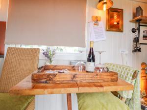 una mesa de madera con una botella de vino. en Bracken Hut at Copy House Hideaway en Barnoldswick