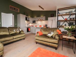 a living room with two couches and a kitchen at The Barn at Copy House Hideaway in Barnoldswick