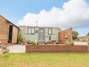 une maison avec une clôture en bois et une cour dans l'établissement Heather Hut at Copy House Hideaway, à Barnoldswick