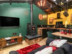 a living room with a couch and a wood stove at Shed Gwely in Abergavenny