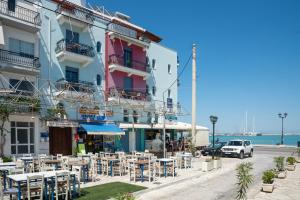 a group of tables and chairs in front of a building at Saint Loukas Studios in Zakynthos