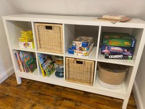 a white book shelf filled with toys and games at Ferienhaus Pollerhof in Lindlar