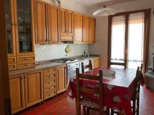 a kitchen with wooden cabinets and a table with a red table cloth at Tuscany Hills Penthouse in Fivizzano
