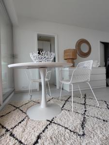 コンカルノーにあるLA SUITE appartement pleine vue merのダイニングルーム(テーブル、椅子付)