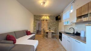a living room with a couch and a kitchen at APARTMA LAVANDA - Apartment Lavanda in Pobegi