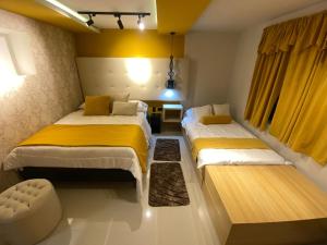 2 Betten in einem gelb-weißen Zimmer in der Unterkunft Home Mark Casa Boutique in Paipa