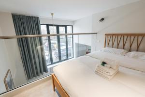 um quarto com 2 camas e uma grande janela em Beautiful and bright duplex nearby Alesia - Paris - Welkeys em Paris