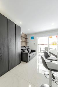 a living room with a couch and a table and chairs at Tenerifeopenhome Luxury comfort Studio in playa Las Americas in Playa de las Americas