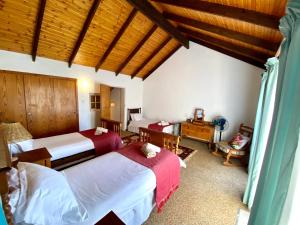 a bedroom with two beds and a wooden ceiling at Mizpah Lodge in Bloemfontein