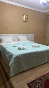 a bedroom with a large bed with two towels on it at Hostel Saba in Kutaisi