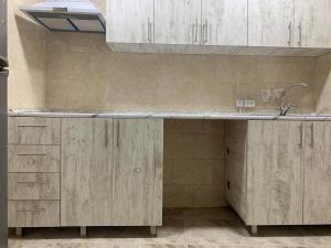 eine Küche mit Holzschränken und einem Waschbecken in der Unterkunft Hostel Saba in Kutaissi